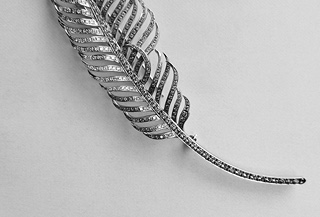 Výjimečná zlatá brož ve tvaru stylizovaného pírka osazená diamanty
