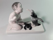 Porcelánový nahý chlapec s tučňákem a krabem 