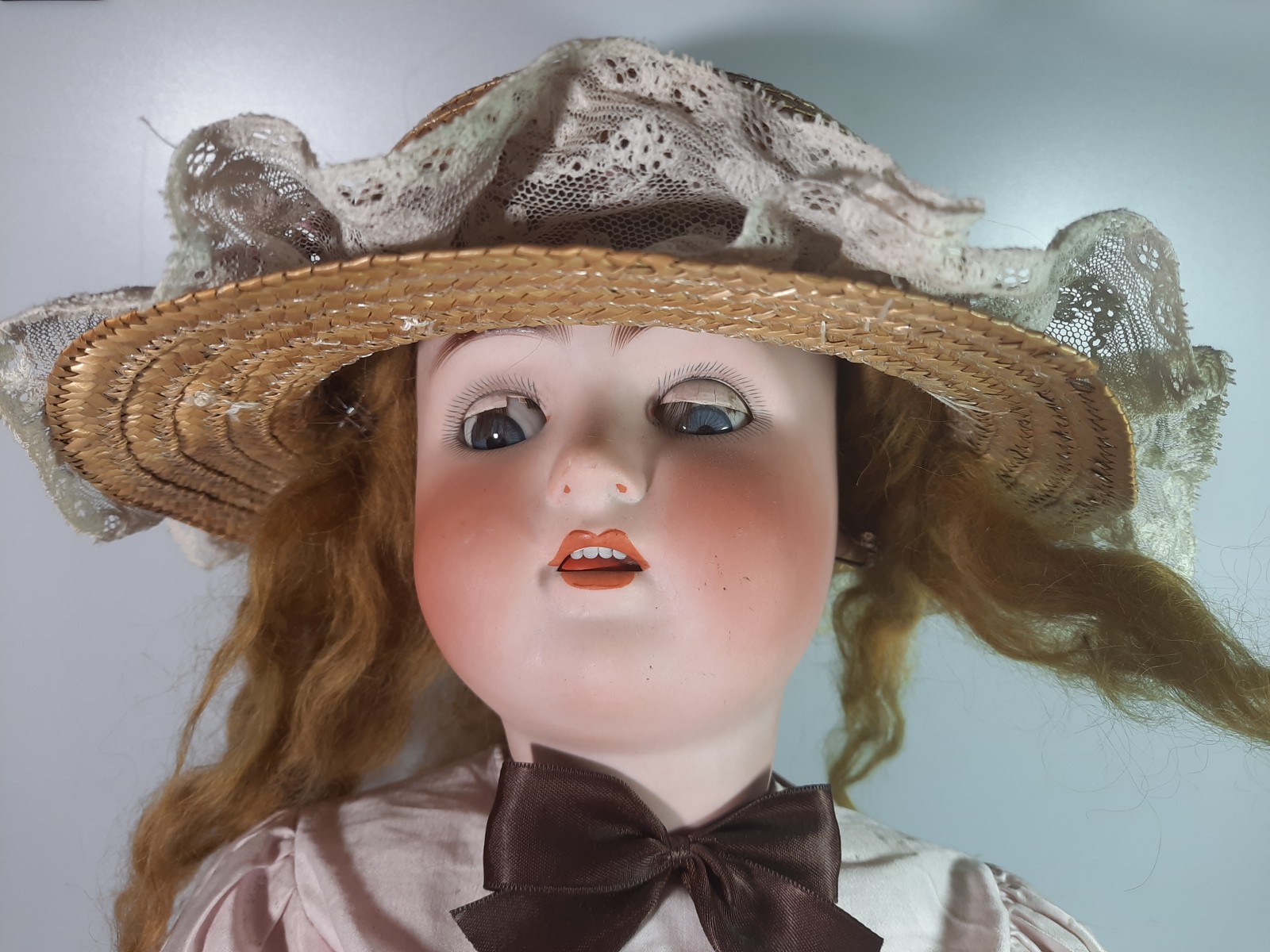 Blonďatá panenka s porcelánovou hlavou v klobouku