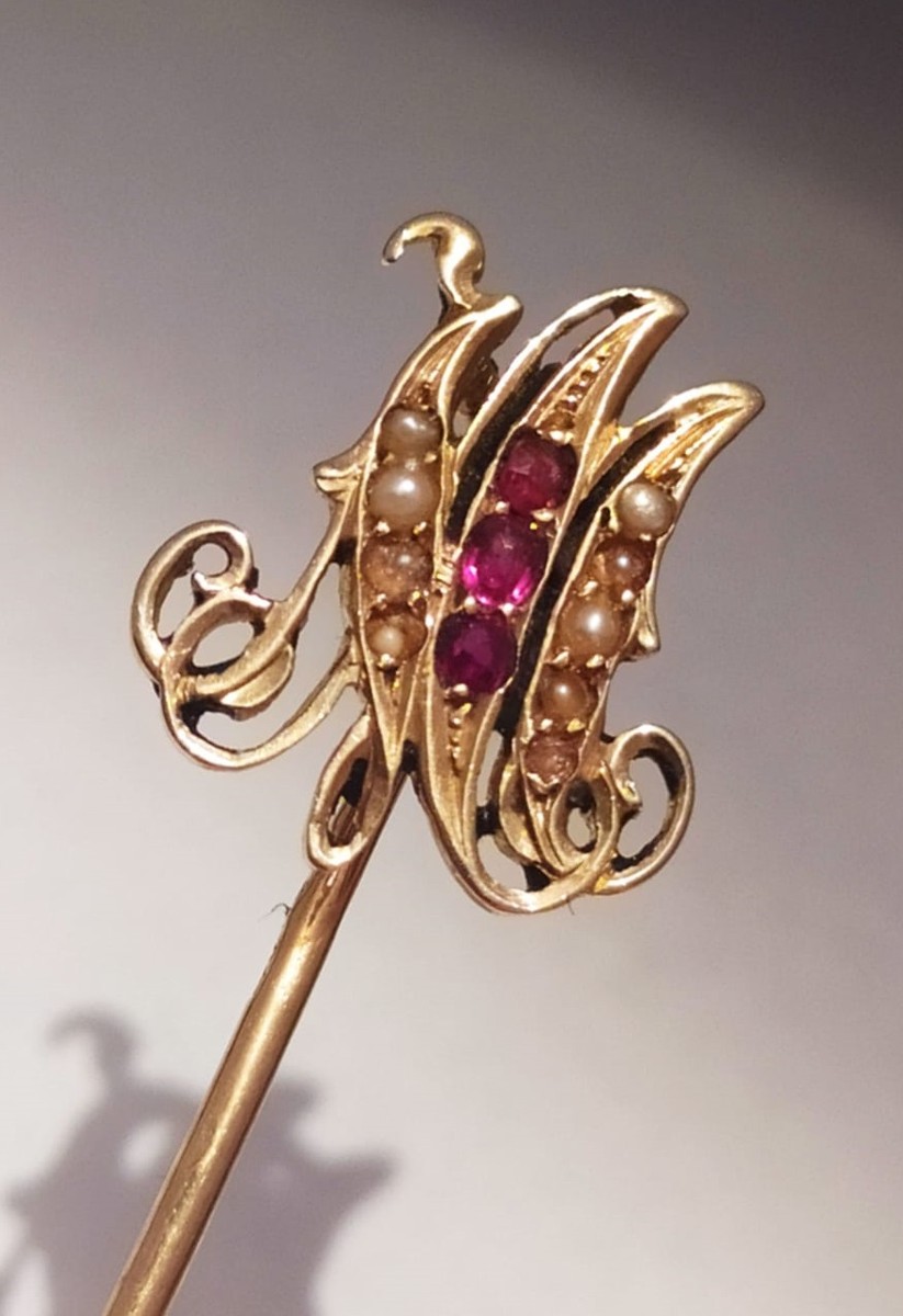 Zlatá jehlice do kravaty s iniciálami zdobená perličkami a rubíny 
