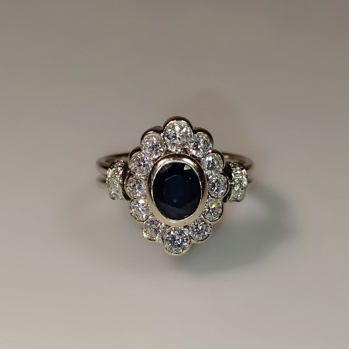 Zlatý prsten s oválným safírem ohraničeným diamanty 